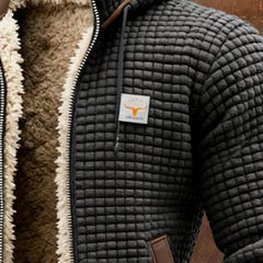 Black quilted fleece jacket with tan sherpa lining, chest logo patch, and zip front