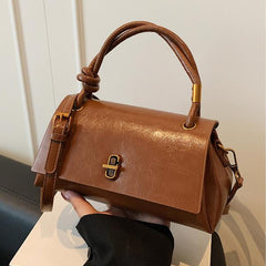 Cognac-brown leather-look crossbody shoulder bag with gold-tone clasp and top flap