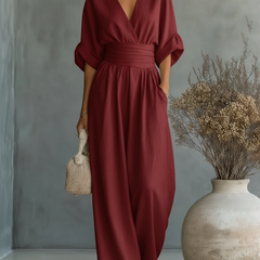 Burgundy V-neck high-waisted jumpsuit with draped sleeves and relaxed wide-leg