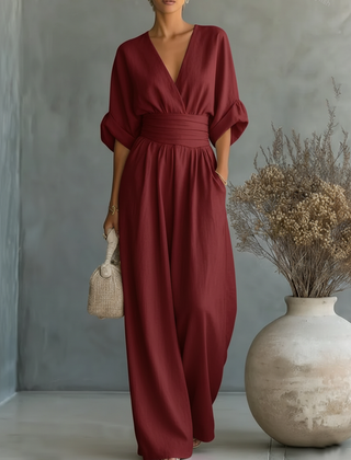 Burgundy V-neck high-waisted jumpsuit with draped sleeves and relaxed wide-leg