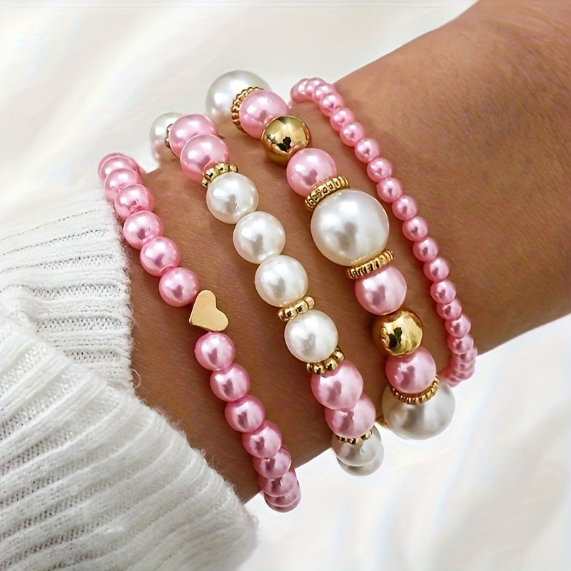 Pearl heart bracelet set on wrist with pink pearls and gold heart and bell charms