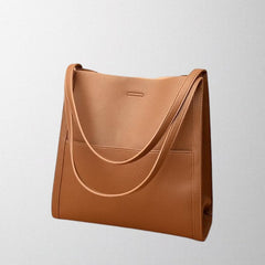 Brown vegan leather shoulder bag with curved front strap and top handles