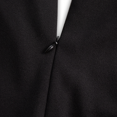 Black midi dress seam with small button-like fastener detail