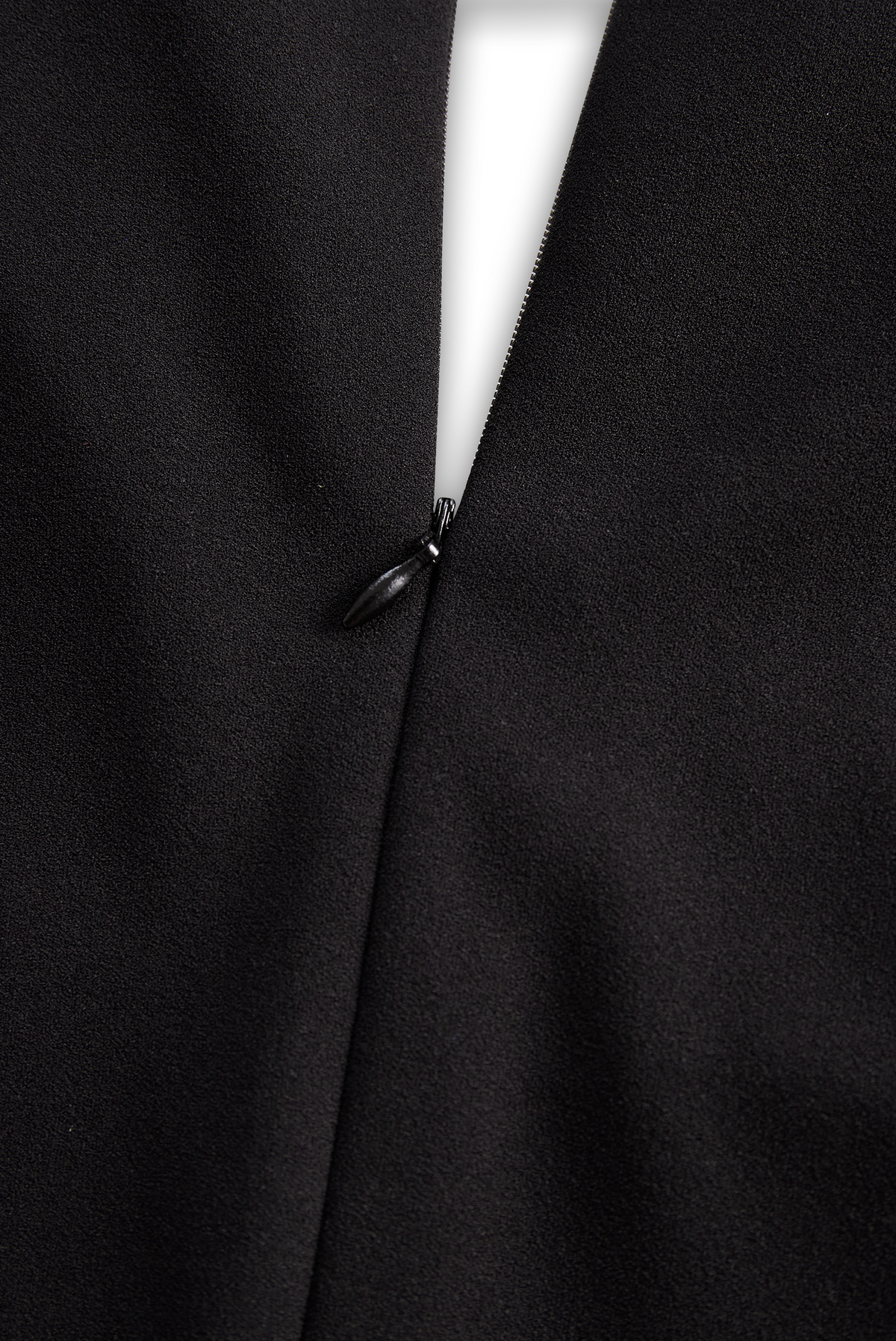 Black midi dress seam with small button-like fastener detail