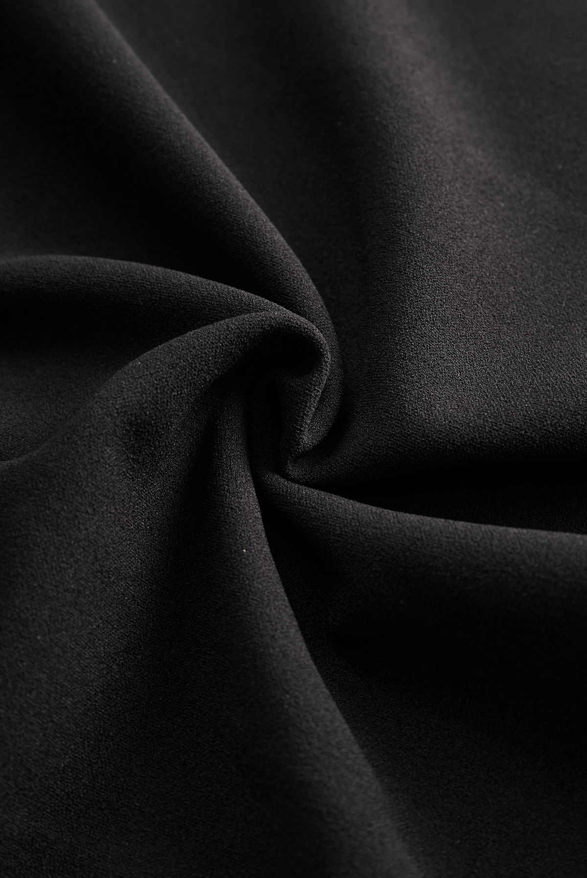 Black midi dress fabric close-up with smooth drape texture