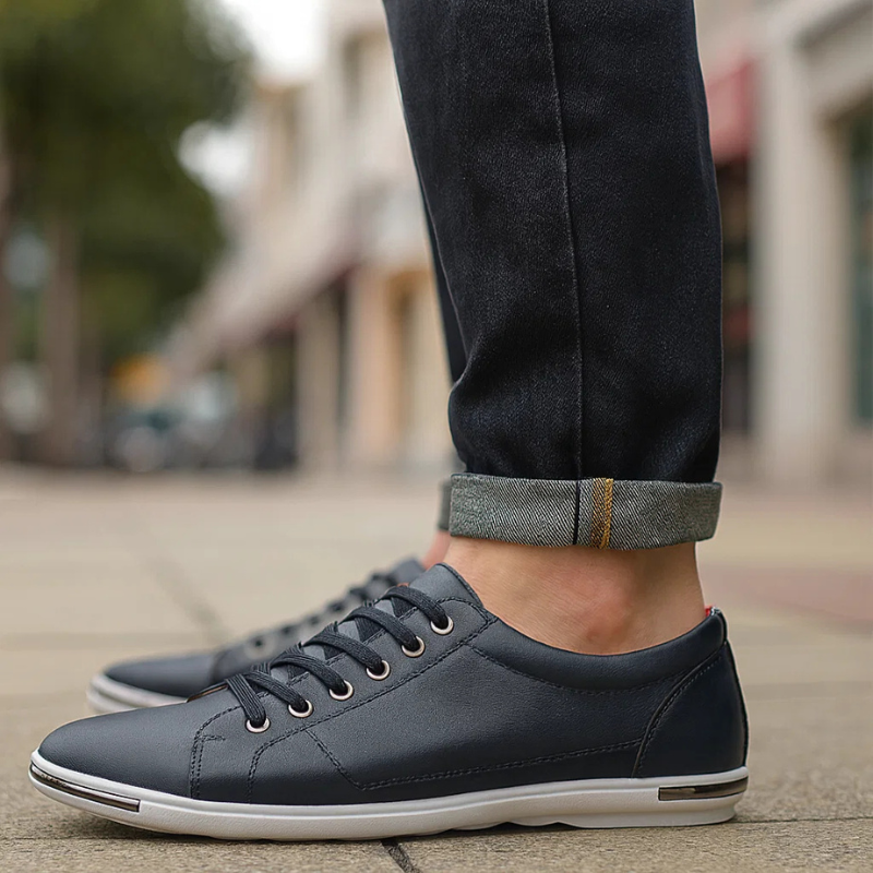 Dark blue leather low-top sneaker with lace-up front and white rubber sole