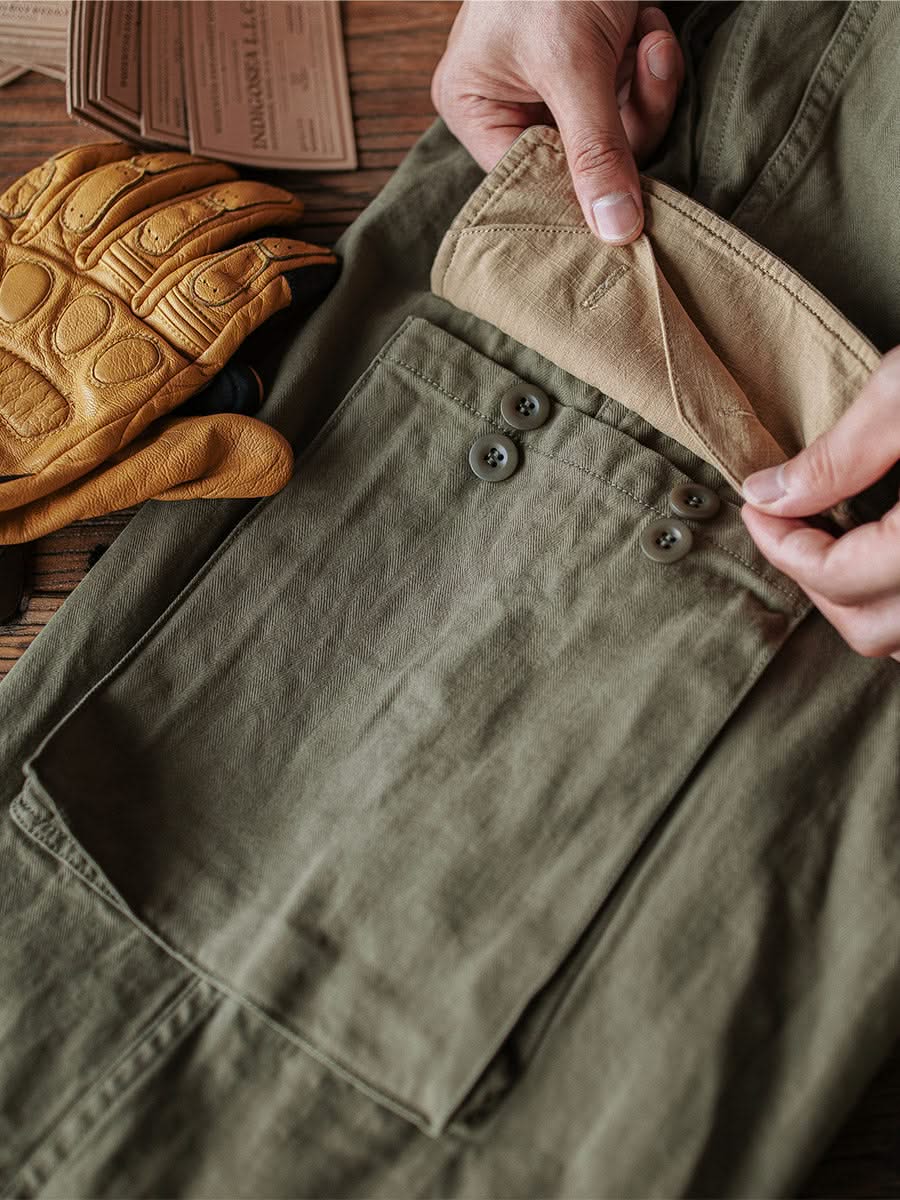 Army green M-47 HBT trousers with flap button pockets and reinforced seams