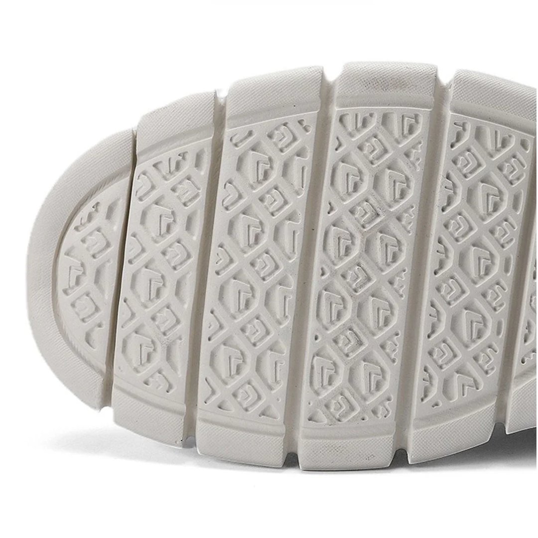 White rubber outsole with deep tread pattern and shock-absorbing flex grooves