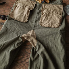 Army green M-47 HBT trousers with large cargo pockets and belt loops