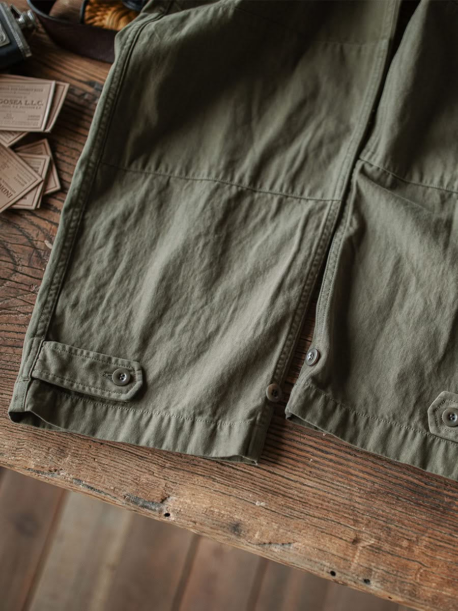 Army green M-47 HBT trouser leg with button tabs and stitched patch pockets