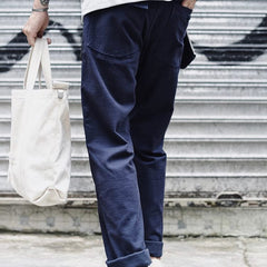 Navy blue straight fatigue pants with cargo pocket seams and cuffed ankle hem
