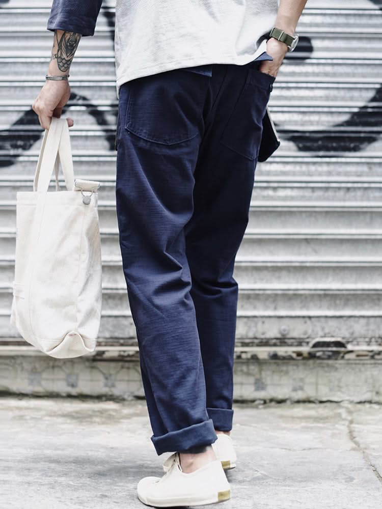 Navy blue straight fatigue pants with cargo pocket seams and cuffed ankle hem