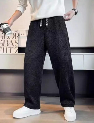 Black textured tapered pants with elastic waistband and drawstring ties