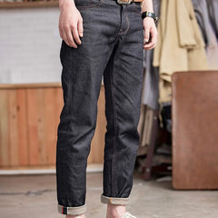 Indigo denim jeans with dark wash, tan belt, cuffed hem and five-pocket design