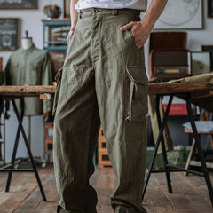 Army green cargo trousers with large flap side pockets and buttoned cuffs