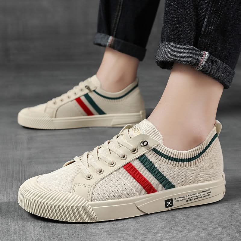 Sandstone knit sneakers on feet with multicolor side stripe and lace-up design