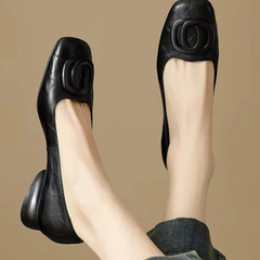 Black leather flats, side view with oval buckle ornament