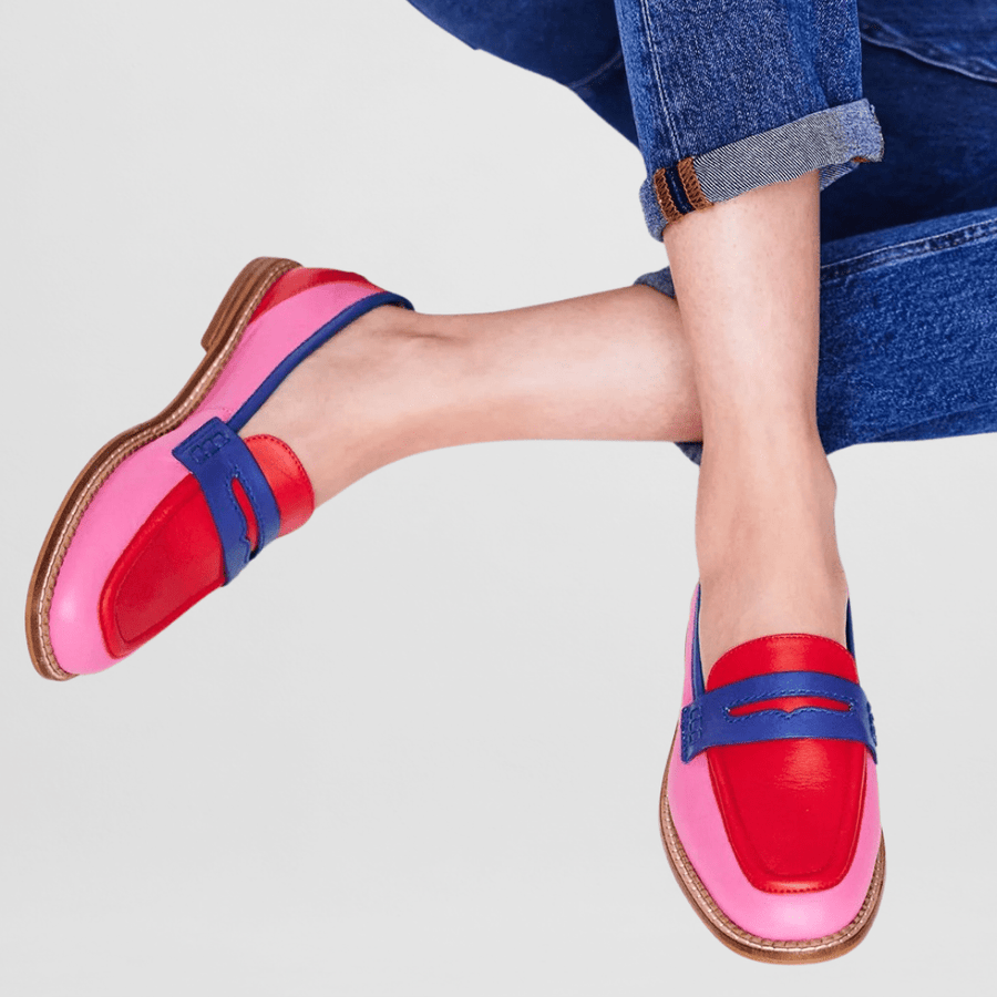 Pink loafers with blue strap and red lining, tan sole, worn with jeans