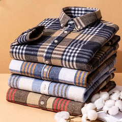 Stack of cotton flannel plaid shirts, mixed colors with button-up collars.