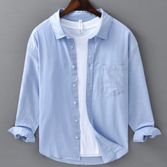 Light blue linen button-up shirt with point collar, chest pocket, and white buttons