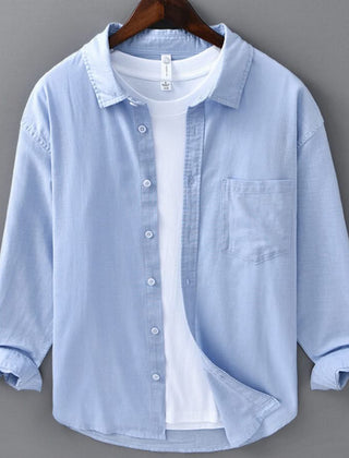 Light blue linen button-up shirt with point collar, chest pocket, and white buttons