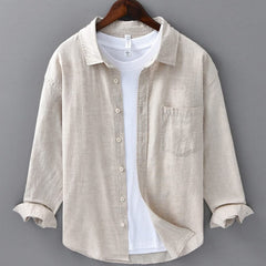 Beige linen button-up shirt with point collar, front pocket, and white buttons