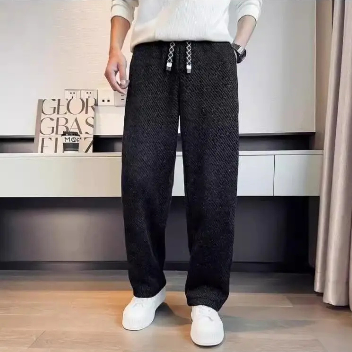 Black textured tapered pants with elastic waistband and drawstring ties