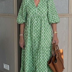 Green patterned V-neck maxi dress with short puff sleeves and flowing skirt