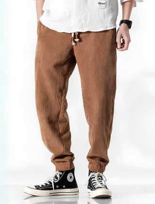 Camel ribbed velvet trousers with tapered legs, elastic cuffs, and drawstring waist