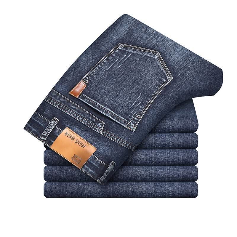Stack of men's stretch denim jeans, blue wash with tan leather patch label