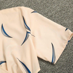 Apricot dress fabric close-up with blue abstract feather-like print