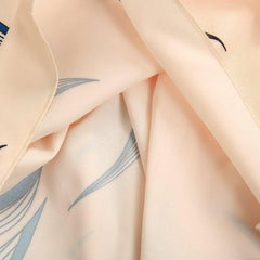 Apricot fabric with blue leaf-swirl print, close-up folds