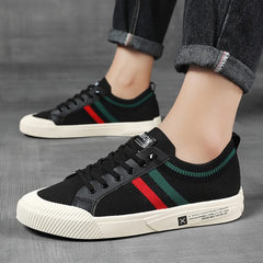 Black knit sneakers on feet with multicolor side stripe and lace-up front