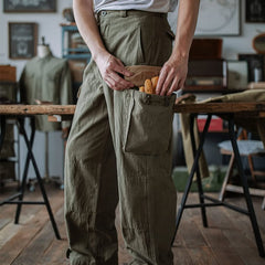 Army green cargo trousers with flap pockets and utility pocket opening at hip