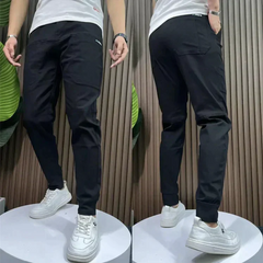 Black stretch utility pants with slanted side pockets and cuffed ankle hem