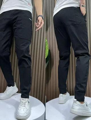 Black stretch utility pants with slanted side pockets and cuffed ankle hem