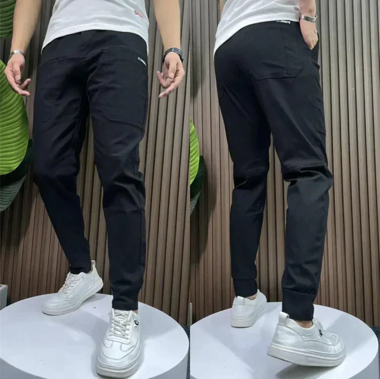 Black stretch utility pants with slanted side pockets and cuffed ankle hem