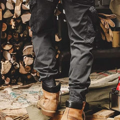 Black utility trousers with cargo pockets, button-flap details, and cuffed cuffs