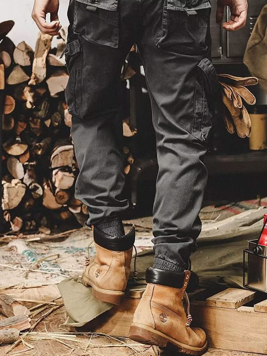 Black utility trousers with cargo pockets, button-flap details, and cuffed cuffs