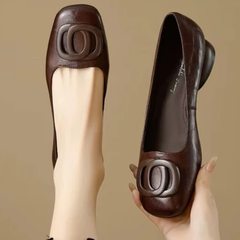 Brown leather flats with oval buckle ornament and low rounded toe