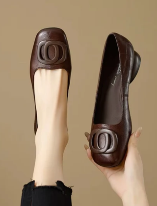Brown leather flats with oval buckle ornament and low rounded toe