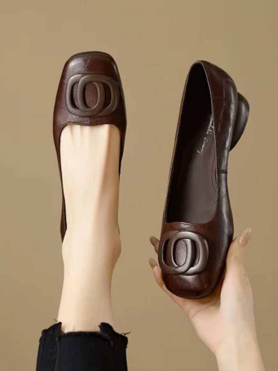Brown leather flats with oval buckle ornament and low rounded toe
