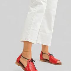 Red leather lace-up sandals with open toe and flat sole