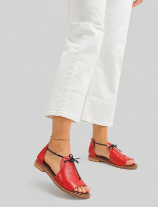 Red leather lace-up sandals with open toe and flat sole