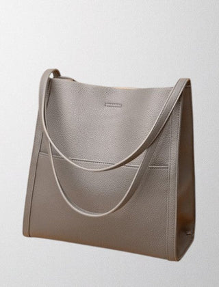 Gray vegan leather shoulder bag with curved strap accent and side panel stitching