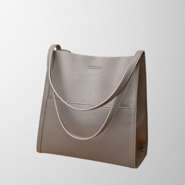 Gray vegan leather shoulder bag with curved strap accent and side panel stitching