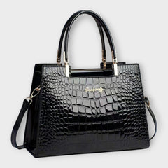 Shiny crocodile-pattern handbag in black with top handles and gold-tone hardware