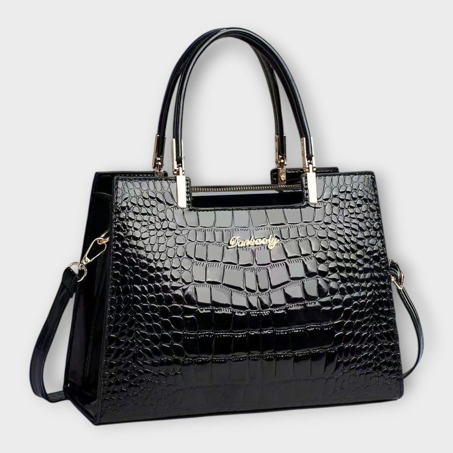 Shiny crocodile-pattern handbag in black with top handles and gold-tone hardware