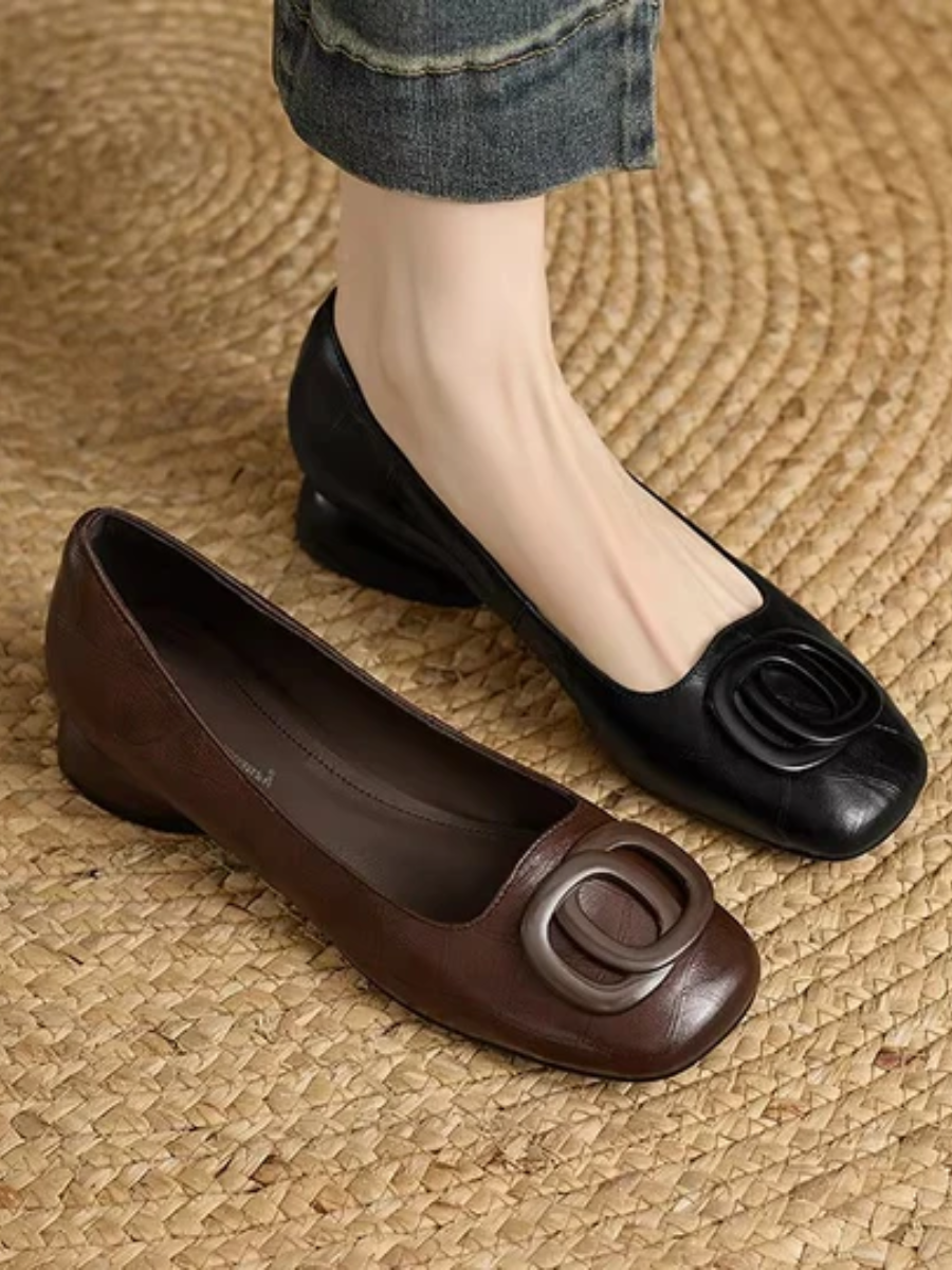 Black and brown leather flats with oval buckle detail and low round toes