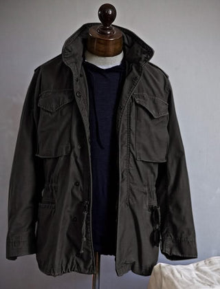 Black heritage utility jacket with hood, snap front, and flap pockets on mannequin